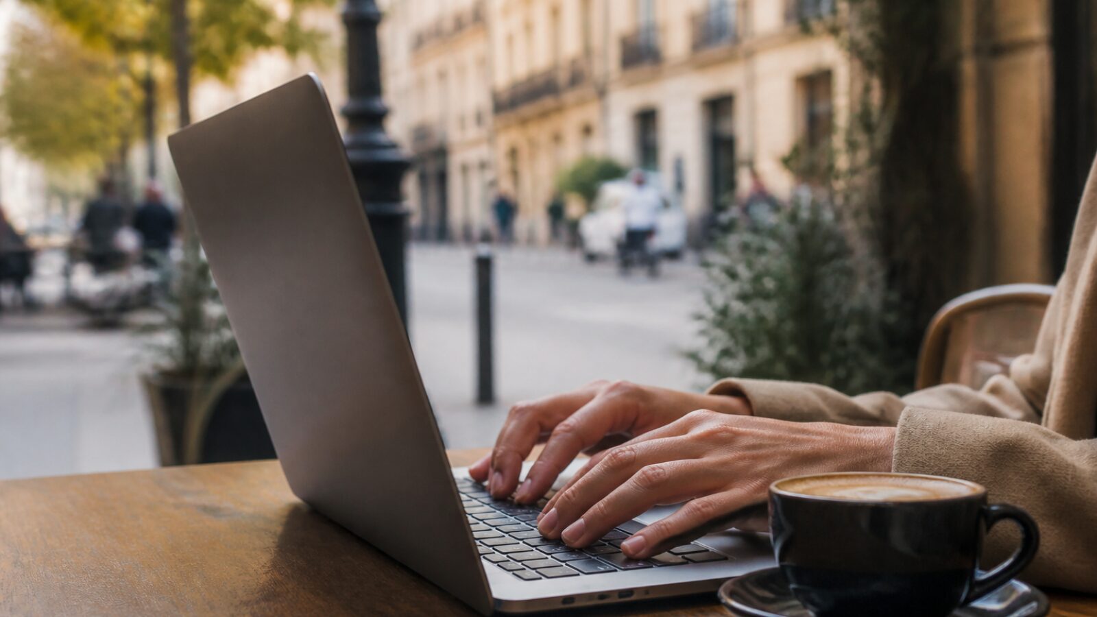 Mains d'un freelance sur un ordinateur portable dans un café